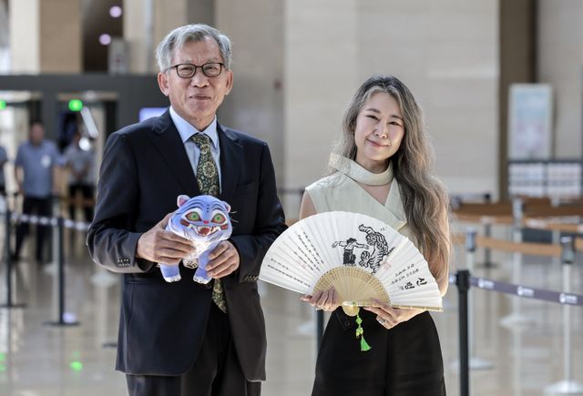 [서울=뉴시스] 정병혁 기자 = 유홍준 국립중앙박물관장과 넷플릭스 영화 ‘케이팝 데몬 헌터스’의 메기 강 감독이 21일 서울 용산구 국립중앙박물관에서 만나 인사를 나누며 선물을 들고 사진을 찍고 있다. 2025.08.21. jhope@newsis.com