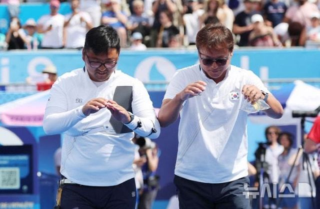 박성수 양궁 남자대표팀 감독과 김우진(왼쪽)이 지난해 8월 4일(한국시간) 레쟁발리드에서 열린 2024파리올림픽 양궁 남자 개인전 결승전에서 승리해 금메달을 확정한 뒤 관중에게 큰절을 하고 있다. 뉴시스