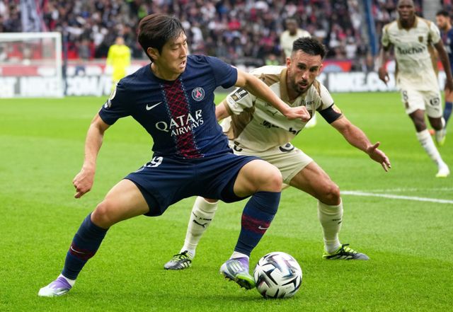PSG 이강인(왼쪽)이 15일(한국시간) 홈에서 열린 랑스와 프랑스 리그앙 4라운드 홈경기에서 상대 선수와 볼을 다투고 있다. 이날 이강인은 오른 발목 통증으로 중도 교체됐다. 파리｜AP뉴시스