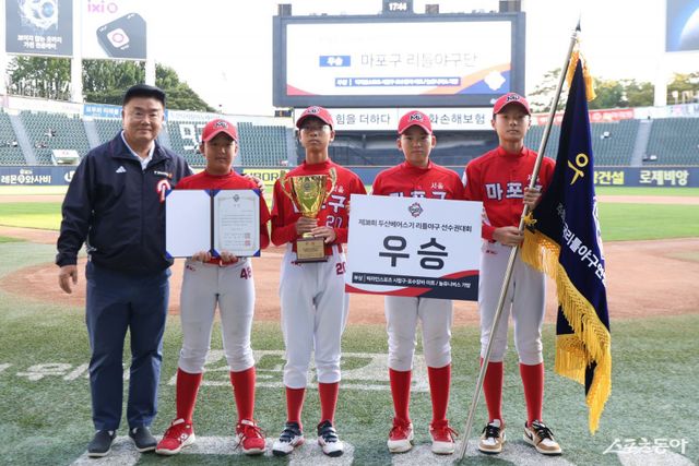 ‘2025 두산베어스기 어린이야구대회’ 리틀부 우승팀 마포구 리틀야구단이 18일 잠실구장에서 진행된 시상식에 참석했다. 김태룡 두산 단장(왼쪽)과 선수들이 기념촬영을 하고 있다. 사진제공｜두산 베어스