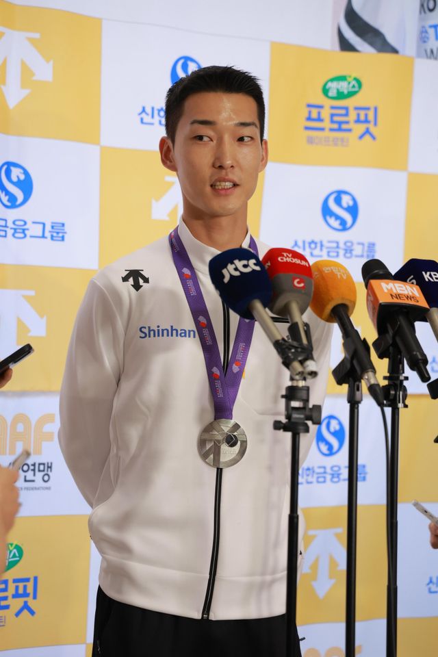 ‘스마일 점퍼’ 우상혁이 18일 김포공항에서 열린 귀국 기자회견에서 2025세계육상선수권 남자 높이뛰기에서 은메달을 수확한 소감을 설명하고 있다. 그는&nbsp;지난달 10일 유럽전지훈련 도중 종아리와 발목을 다쳤지만 이를 딛고 한국육상 역대 최고 성적과 타이인 은메달을 따냈다. 사진제공│대한육상연맹