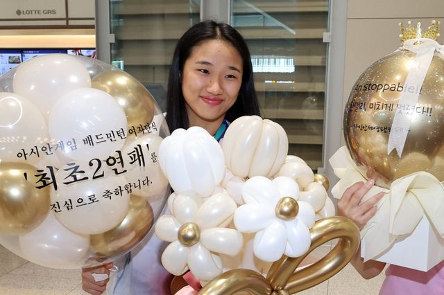 ‘셔틀콕 여제’ 안세영은 아시안게임 여자단식에서 무실게임으로 2연패를 달성하며 세계 최강의 입지를 공고히 했다. 9월 30일 금메달을 목에 걸고 인천국제공항으로 귀국한 뒤 팬들의 선물을 받고 기뻐하는 모습. 인천국제공항│뉴시스