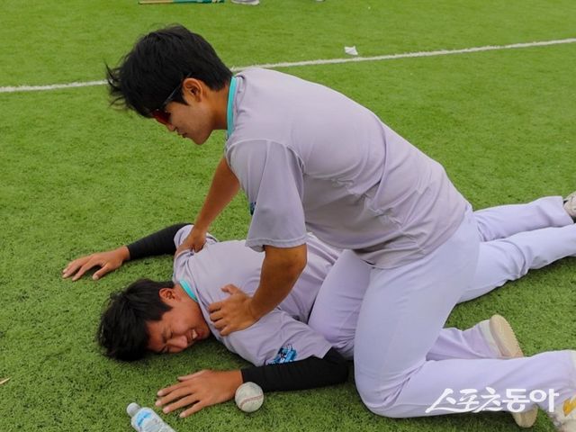 KT 임준형(위)이 13일 호주 질롱 베이스볼 센터서 열린 스프링캠프 도중 김동현과 컨디션 조절 방법을 공유하고 있다. 사진제공｜KT 위즈