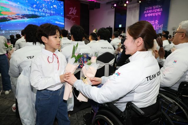 2026밀라노·코르티나담페초동계패럴림픽에 출전할 컬링 믹스더블 백혜진(오른쪽)이 2일 송파구 올림픽파크텔에서 열린 결단식에서 화동으로부터 꽃을 선물받으며 활짝 웃고 있다. 뉴시스