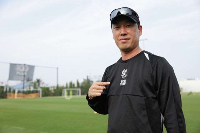 이정규 광주 감독이 지난달 태국 후아힌에서 열린 1차 동계전지훈련서 상의 엠블럼을 가리키고 있다. 사진제공｜한국프로축구연맹