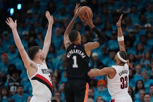 샌안토니오 빅토르 웸반야마(가운데)가 20일(한국시간) 프로스트뱅크 센터서 열린 포틀랜드와 NBA&nbsp;PO 1라운드 1차전 도중 도노반 클링언(왼쪽)과 투마니 카라마 사이에서 슛을 던지고 있다. 샌안토니오｜AP뉴시스