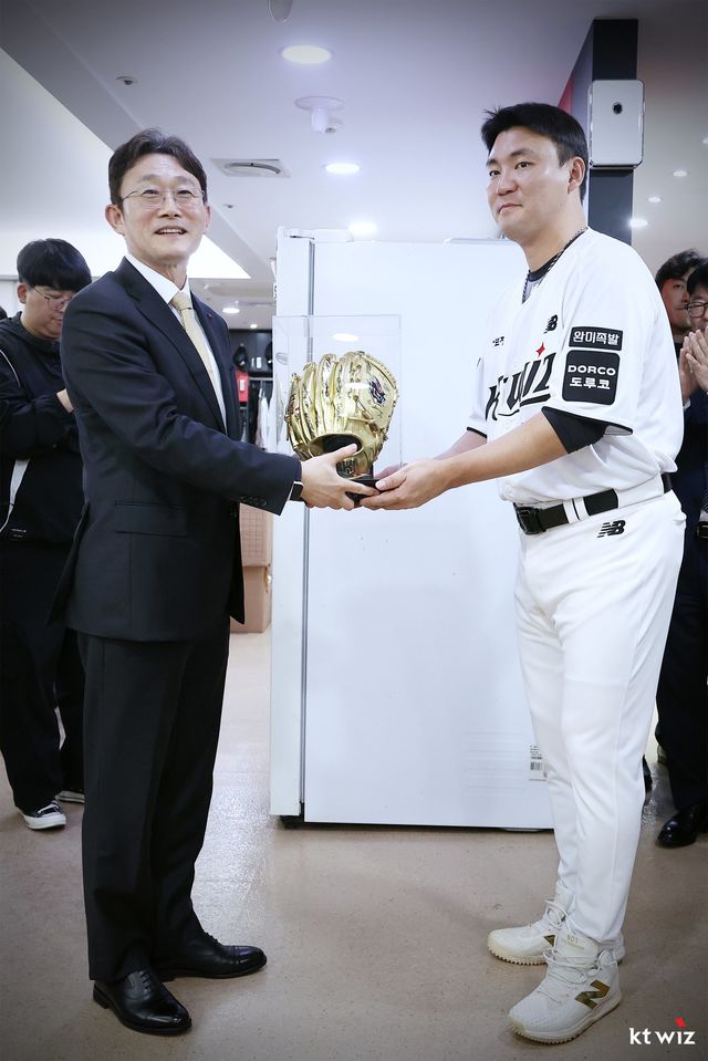 박윤영 KT 대표이사(왼쪽)가 12일 수원KT위즈파크서 진행된 선수단 상견례에서 팀 주장 장성우로부터 구단이 제작한 골든글러브 선물을 받고 있다. 사진제공｜KT 위즈