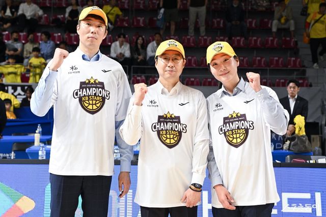 김완수 KB스타즈 감독(가운데)이 지난달 26일 용인체육관서 열린 챔피언 결정전 3차전서 삼성생명을 꺾고 우승을 차지한 뒤 오정현 수석코치(왼쪽), 정미란 코치와 기념 촬영하고 있다. 사진제공｜WKBL