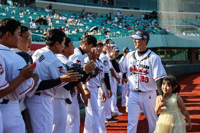 울산 고효준(29번)이 28일 롯데와 퓨처스(2군)리그 경기가 열리기 전 딸과 함께 선수단에 환영받고 있다. 사진제공｜울산 웨일즈
