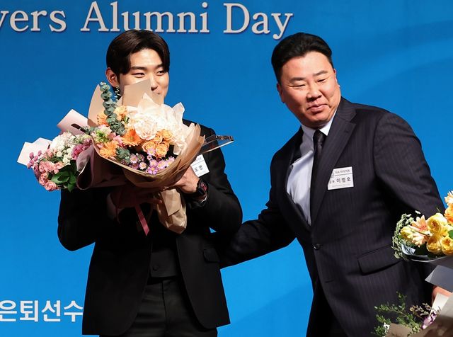 1일 오후 서울 강남구 청담동 한 호텔에서 열린 한국프로야구은퇴선수협회 은퇴선수의 날 시상식에서 '최고의 선수상'을 받은 KIA 김도영이 KIA 이범호 감독(오른쪽)으로부터 꽃다발을 받고 있다. 연합뉴스