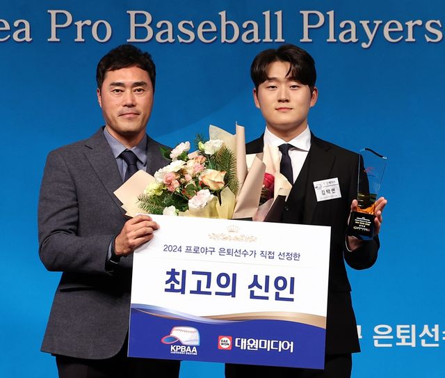 두산 김택연이 1일 오후 서울 강남구 청담동 한 호텔에서 열린 한국프로야구은퇴선수협회(한은회) 은퇴선수의 날 시상식에서 '최고의 신인상'을 받은 뒤 안경현 한은회 회장과 기념 촬영을 하고 있다. 연합뉴스