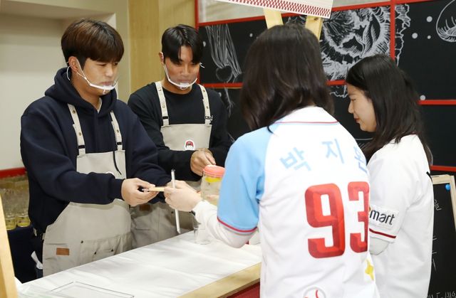 SSG 랜더스가 30일 인천SSG랜더스필드 지하1층에 위치한 직원식당에서 자선 식당&카페 '캐처테이블'을 진행했다. 김민식(왼쪽)과 박지환(오른쪽)이 팬들에게 음료와 쿠키를 제공하고 있다. SSG 랜더스