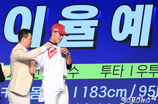 11일 오후 서울 신천동 롯데호텔 월드에서 열린 '2025 KBO 신인 드래프트'에 참석한 SSG 김재현 단장이 1라운드 8순위로 강릉고 이율예를 지명한 뒤 유니폼을 입혀주고 있다. 엑스포츠뉴스 DB