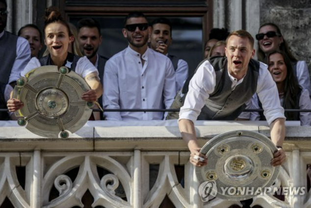 독일 분데스리가 바이에른 뮌헨의 남성팀 주장 마누엘 노이어, 여성팀 주장 리나 마굴이 지난해 5월29일 뮌헨 마리엔 광장에서 열린 시즌 우승 자축 행사에서 방패 모양의 우승 트로피를 함께 들어올리고 있다. 연합뉴스