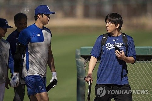 미국 메이저리그 LA 다저스의 슈퍼스타 오타니 쇼헤이와 그의 전 통역 미즈하라 잇페이가 훈련장으로 이동하며 대화를 나누고 있다. AP/연합뉴스