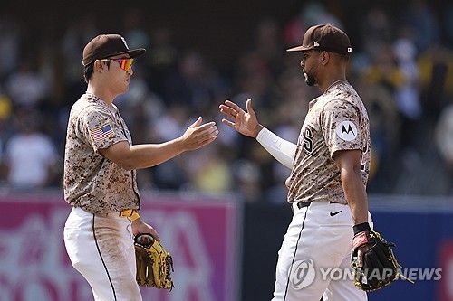 왼쪽에 선 샌디에이고 파드리스 김하성이 22일(이하 한국시간) 미국 캘리포니아주 샌디에이고의 펫코파크에서 열린 2024 미국 메이저리그(MLB) 정규시즌 토론토 블루제이스와 홈경기에서 승리한 뒤 팀 동료 잰더 보가츠와 하이파이브 하고 있다. 이날 김하성은 6번 타자 겸 유격수로 선발 출전해 2타수 무안타 2볼넷 2도루 2득점을 올렸다.​ AP/연합뉴스