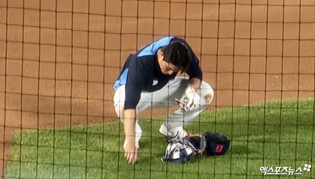 ​​ 롯데 자이언츠 내야수 이주찬이 경기 후 특별 훈련을 앞두고 잔디를 만지고 있다. 그는 이날 강습 타구를 놓치는 등 실책을 저질렀고, 이를 아쉬워하고 있다. 사직, 박정현 기자