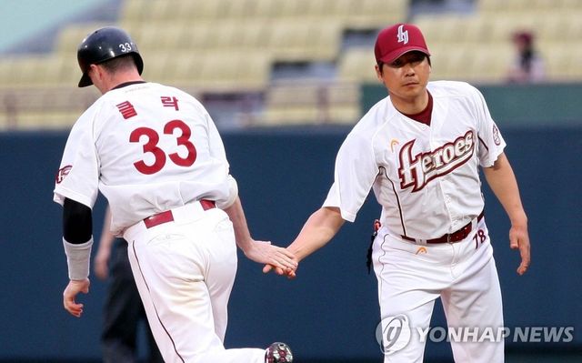2009년 히어로즈 1군 작전 주루코치로 지도자 커리어를 시작했던 홍원기(오른쪽) 현 키움 히어로즈 감독이 당시 외국인 타자였던 덕 클락의 홈런 후 하이파이브를 하면서 격려하던 모습. 사진 연합뉴스