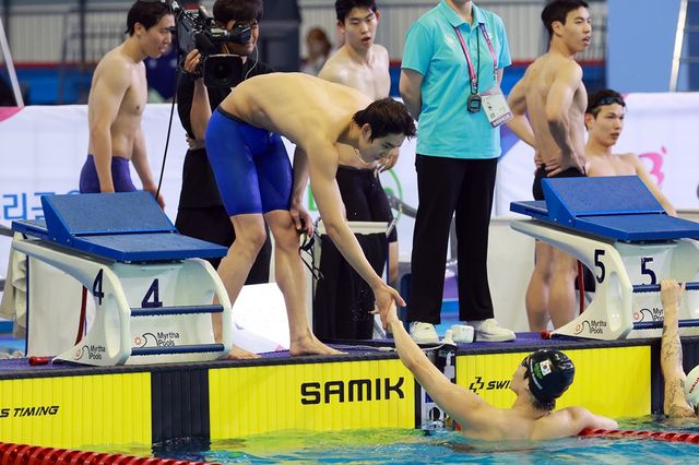 19일 부산 아시아드주경기장에서 열린 제106회 전국체육대회 수영 남자 계영 800m에서 황선우(강원도청)가 1위로 레이스를 마친 뒤 김우민(강원도청)과 손을 맞대고 있다. 사진 연합뉴스