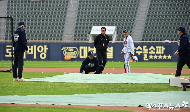 26일 오후 서울 송파구 잠실야구장에서 열리는 '2025 신한 SOL Bank KBO 한국시리즈' 한화 이글스와 LG 트윈스의 1차전 경기에 앞서 그라운드 정비 직원들이 마운드에 방수포를 덮고 있다. 잠실, 박지영 기자