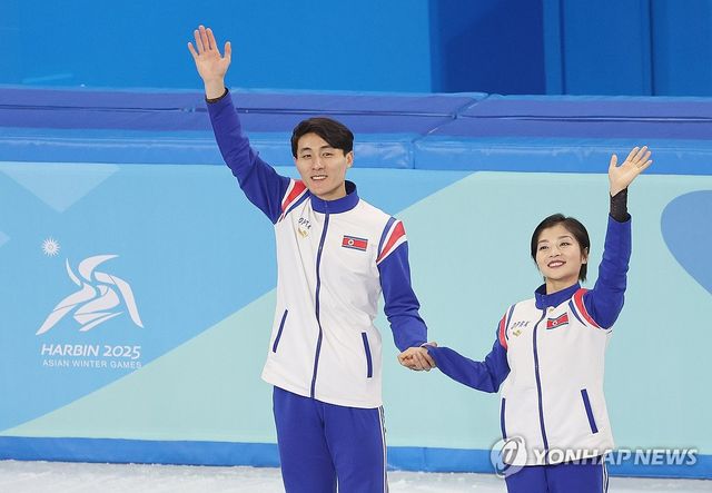 북한 피겨스케이팅 한금철(왼쪽)과 렴대옥이 12일 중국 하얼빈 헤이룽장 빙상훈련센터 다목적홀에서 열린 2025 하얼빈 동계아시안게임 피겨 페어 종목에서 은메달을 획득한 뒤 시상대에 오르며 손을 흔들고 있다. 연합뉴스