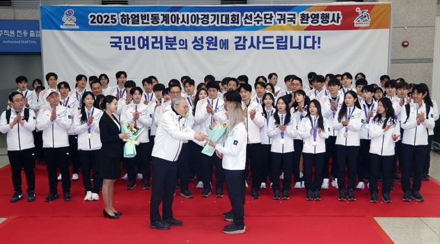 15일 오후 인천국제공항 제1여객터미널에서 열린 2025 하얼빈 동계아시안게임 대한민국 선수단 귀국 환영행사, 유인촌 문화체육관광부 장관이 꽃다발을 전달하고 있다. 연합뉴스