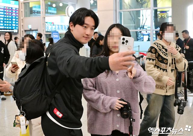 KIA 타이거즈 선수단이 미국 캘리포니아주 어바인 그레이트 파크 베이스볼 컴플렉스에서 진행한 1차 스프링캠프를 마치고 19일 오후 인천국제공항을 통해 귀국했다. KIA 윤도현이 팬과 기념사진을 촬영하고 있다. 엑스포츠뉴스 DB