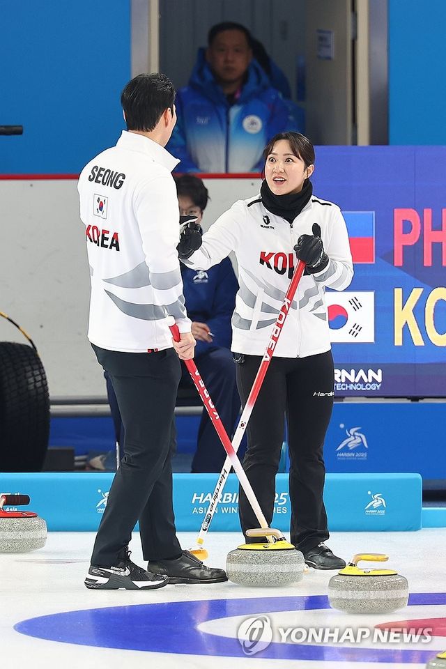 김경애와 성지훈이 4일 중국 하얼빈에서 열린 2025 하얼빈 동계아시안게임 컬링 믹스더블 필리핀전을 마치고 서로를 격려하고 있다. 연합뉴스