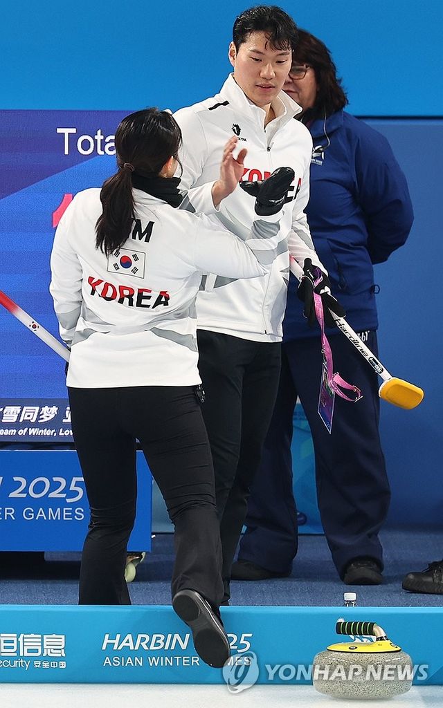 김경애-성지훈 조가 중국 하얼빈에서 열린 2025 하얼빈 동계아시안게임 컬링 믹스더블 조별예선 경기에서 하이파이브하고 있다. 연합뉴스