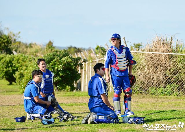 홀로 일어서 있는 삼성 라이온즈 포수 강민호가 올해 스프링캠프에서 후배들과 수비 훈련에 임하고 있다. 엑스포츠뉴스 DB