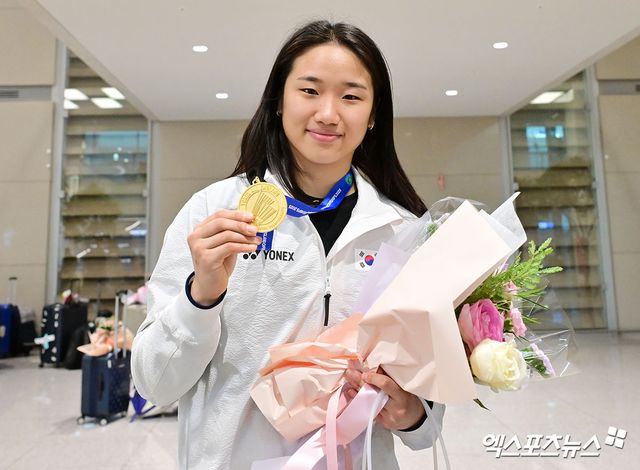 세계배드민턴연맹(BWF) 월드투어 슈퍼 1000 전영오픈 여자 단식에서 우승을 차지한 '라켓의 황제' 안세영(삼성생명)이 18일 오후 인천국제공항을 통해 귀국했다. 메달을 들고 포즈취하는 안세영. 엑스포츠뉴스DB