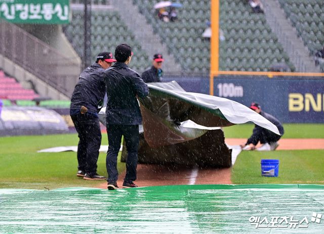 12일 오후 서울 송파구 잠실야구장에서 열릴 예정인 2025 신한 SOL Bank KBO리그 두산 베어스와 LG 트윈스의 경기, 비바람이 부는 가운데 야구장 관계자들이 방수포를 설치하고 있다. 엑스포츠뉴스 잠실, 김한준 기자