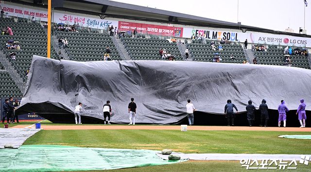 12일 오후 서울 송파구 잠실야구장에서 열릴 예정인 2025 신한 SOL Bank KBO리그 두산 베어스와 LG 트윈스의 경기, 비바람이 부는 가운데 야구장 관계자들이 방수포를 설치하고 있다. 엑스포츠뉴스 잠실, 김한준 기자