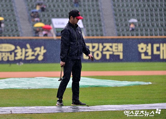 12일 오후 서울 송파구 잠실야구장에서 열릴 예정인 2025 신한 SOL Bank KBO리그 두산 베어스와 LG 트윈스의 경기, 비바람이 부는 가운데 야구장 관계자들이 방수포를 설치하고 있다. 엑스포츠뉴스 잠실, 김한준 기자