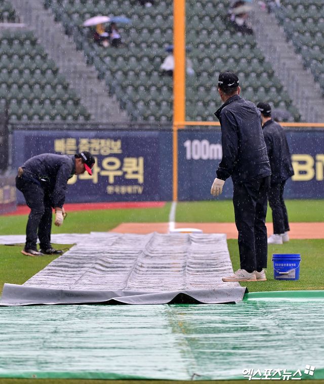 12일 오후 서울 송파구 잠실야구장에서 열릴 예정인 2025 신한 SOL Bank KBO리그 두산 베어스와 LG 트윈스의 경기, 비바람이 부는 가운데 야구장 관계자들이 방수포를 설치하고 있다. 엑스포츠뉴스 잠실, 김한준 기자