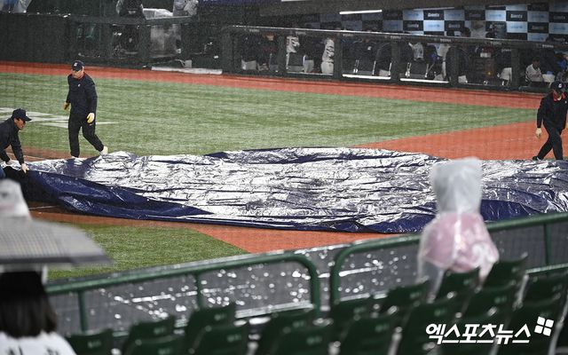 23일 오후 부산 동래구 사직야구장 열린 '2024 신한 SOL Bank KBO리그' SSG 랜더스와 롯데 자이언츠의 경기, 5회초 우천으로 인해 경기가 중단된 뒤 그라운드에 방수포가 뎦여지고 있다. 엑스포츠뉴스 DB
