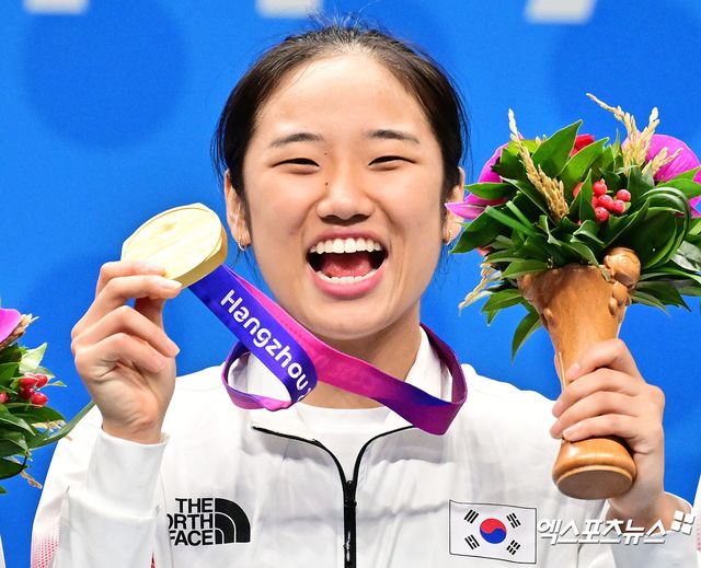 한국 배드민턴 간판 안세영이 2023년 열린 항저우 아시안게임에서 금메달을 딴 뒤 미소 짓고 있다. 엑스포츠뉴스 DB