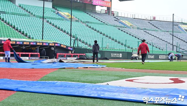 10일 오후 인천SSG랜더스필드에서 열리는 '2025 신한 SOL Bank KBO리그' KIA 타이거즈와 SSG 랜더스의 경기, 야구장 관계자들이 방수포를 정리하고 있다. 문학, 김한준 기자