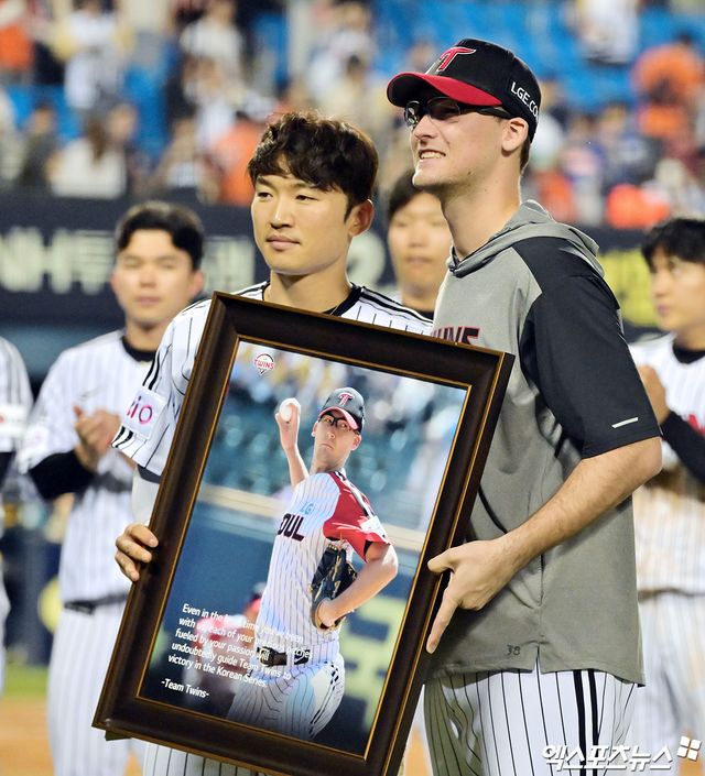 LG 트윈스 캡틴 박해민(왼쪽)이 28일 잠실 한화 이글스전 종료 후 단기 대체 계약 종료로 팀을 떠나게 된 외국인 투수 코엔 윈에게 기념 액자를 전달했다. 사진 김한준 기자