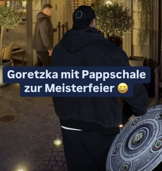 레온 고레츠카가 바이에른 뮌헨 우승 축하연에 해리 케인에게 줄 마이스터 샬레(분데스리가 우승 트로피) 종이 버전을 갖고 걸어가고 있다. 빌트