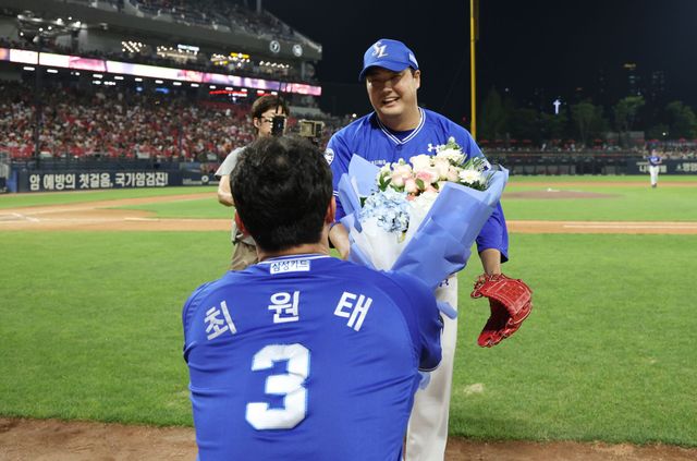삼성 라이온즈 김태훈이 12일 광주 KIA 타이거즈전에서 6년 연속 10홀드를 달성한 뒤 최원태에게 꽃다발을 받고 있다. 삼성 라이온즈