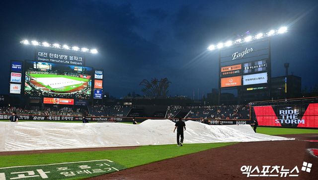 15일 오후 대전 한화생명 볼파크에서 열린 '2025 신한 SOL Bank KBO리그' LG 트윈스와 한화 이글스의 경기, 5회말 우천중단된 가운데 구장관리자들이 방수포를 철수하고 있다. 엑스포츠뉴스DB