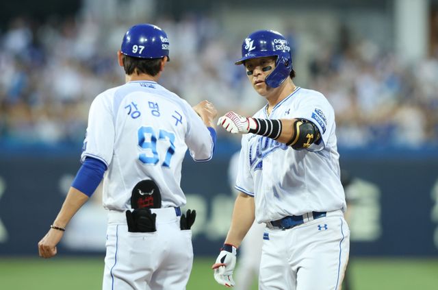 삼성 라이온즈 포수 강민호가 올해 정규시즌 경기에 출전해 안타를 친 뒤 1루에서 코치와 세리머니하고 있다. 삼성 라이온즈