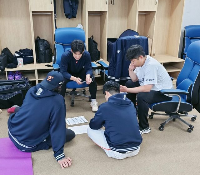 최재훈과 폰세, 김지환 통역, 김승리 전력분석파트장이 함께 경기 전 상대 팀 전력분석 및 전략 구상을 하고 있다. 한화 이글스 제공