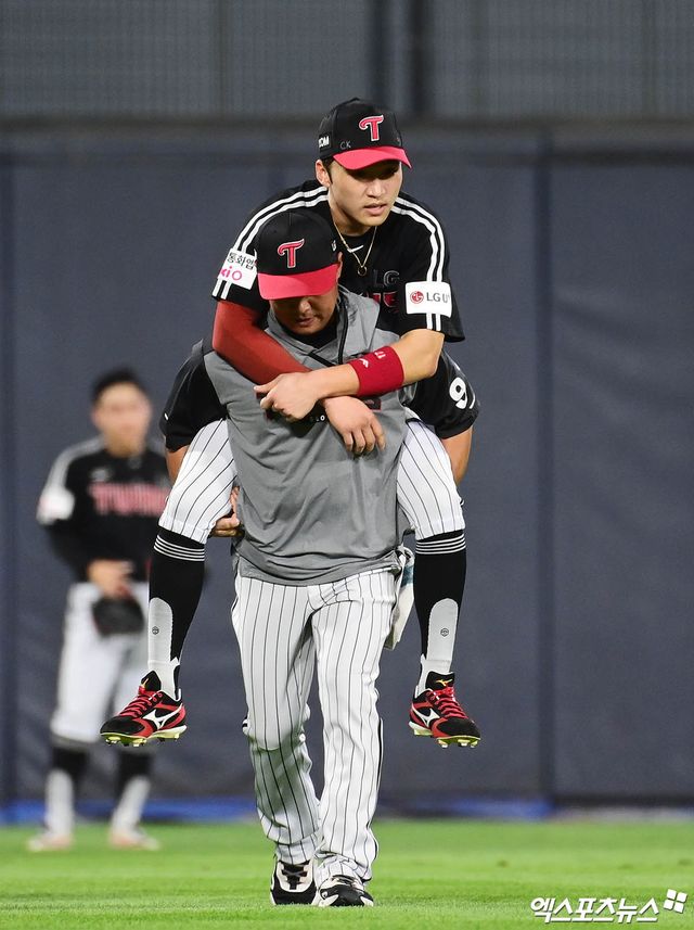 12일 오후 수원케이티위즈파크에서 열린 '2025 신한 SOL Bank KBO리그' LG 트윈스와 KT 위즈의 경기, 8회말 2사 1,2루 KT 오윤석의 2타점 적시 3루타 때 LG 중견수 박해민이 수비 이후 다리 통증을 호소, 트레이닝 코치에게 업힌 채 그라운드를 빠져나오고 있다. 엑스포츠뉴스 수원, 박지영 기자
