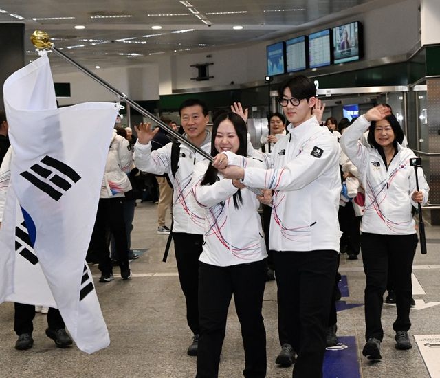 스피드스케이팅 박지우(왼쪽)와 쇼트트랙 이준서가 31일(한국시간) 이탈리아 밀라노 말펜사 국제공항에서 대한민국 선수단을 대표해 태극기를 들고 있다. 사진 대한체육회