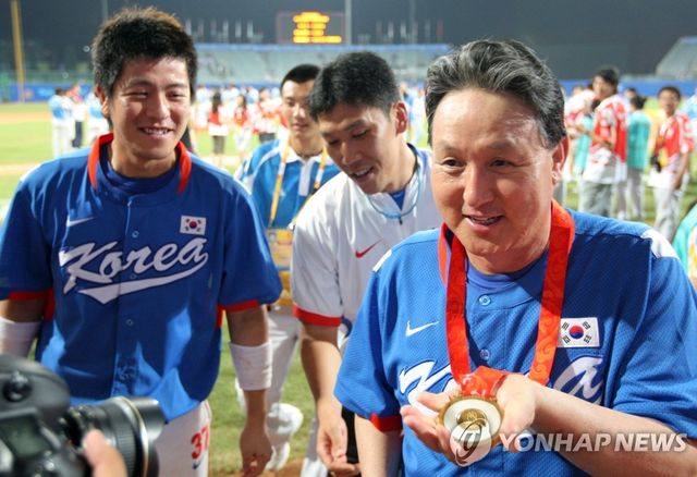 김경문(오른쪽) 감독이 2008 베이징 올림픽 결승에서 쿠바를 꺾은 뒤 강민호(왼쪽)가 걸어준 금메달을 바라보며 웃고 있는 모습. 사진 연합뉴스