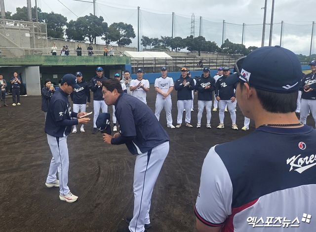 류현진(가운데)이 17일 일본 오키나와 고친다 구장에서 진행된 WBC 대표팀 훈련에 앞서 투수조 대표로 류지현 감독이 준비한 세뱃돈을 받았다. 사진 김지수 기자