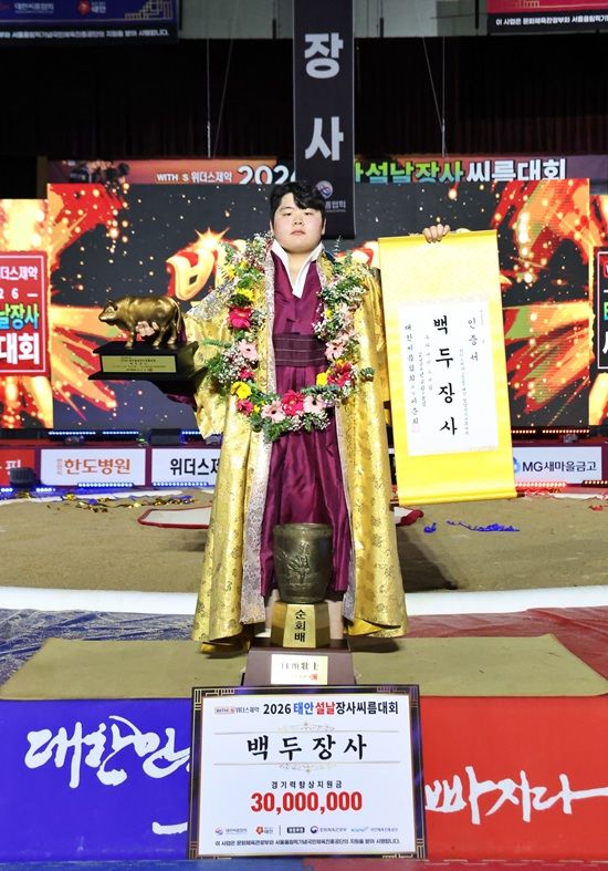 18일(수) 충청남도 태안군 태안종합실내체육관에서 열린 ‘위더스제약 2026 태안설날장사씨름대회’ 백두장사(140kg이하)에 등극한 김민재(영암군민속씨름단)가 장사인증서와 황소트로피를 들고 기념사진을 찍고 있다.