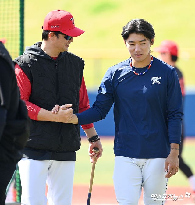 2026 월드베이스볼클래식(WBC) 출전을 준비 중인 김도영(오른쪽)이 24일 일본 오키나와 가네다 구장에서 열리는 소속팀 KIA 타이거즈와 연습경기에 앞서 손승락 수석코치와 대화하는 모습. 사진 고아라 기자